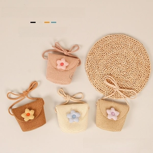 Close-up of four colors of handmade woven straw bags with checkered flower details