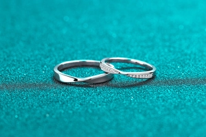 Close-up of S925 sterling silver couple rings with Mobius twist and inlaid moissanite