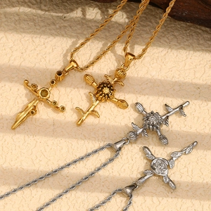 Flat lay of four gold and silver necklaces with floral and cross pendants on beige texture