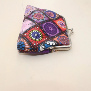 Macro side view of a vintage mandala print coin purse with a metal kiss-lock clasp