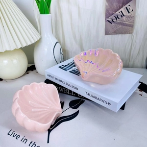 Dettaglio di vassoi in ceramica a forma di conchiglia rosa e perlata per gioielli