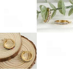 Detail of 18K gold plated hoop earrings with crystals and polished finish on wood base