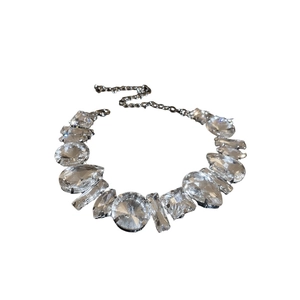 Exaggerated silver crystal choker necklace with geometric rhinestones on white background