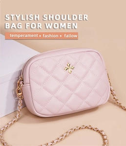 Detail of pink quilted leather shoulder bag with gold cross hardware and chain strap