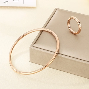Close-up of polished rose gold ring and bangle set on a premium jewelry box
