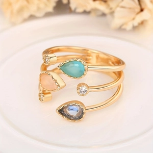 Macro detail of multi-layer gold ring featuring pear-shaped stones and zircons