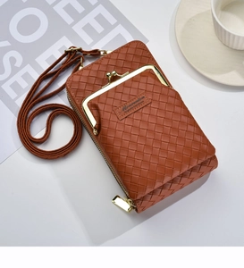 Détail de sac téléphone en cuir tressé marron avec fermoir doré et étiquette