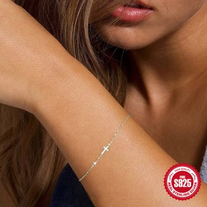 Minimalist 925 sterling silver cross bracelet with sparkling zircon on a woman wrist