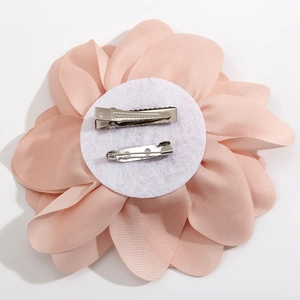 Detail of soft pink flower brooch back with metal alligator clip and safety pin attachment