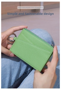 Close-up of grass green litchi grain leather coin purse with zipper and metal ring