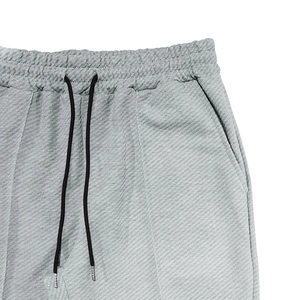 Detail of light grey corduroy jogger waist with drawstring and metal tips