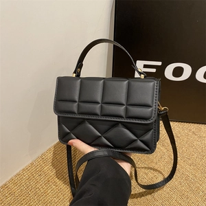 Elegant black quilted shoulder bag with gold hardware and top handle for women