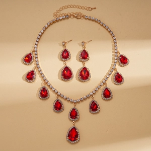 Détail de parure bijoux gouttes de pierres rouges avec finition dorée pour mariages