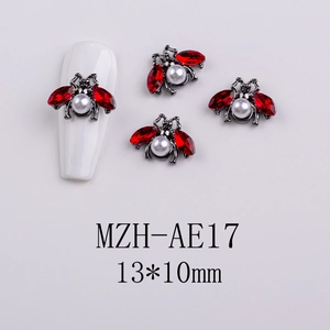 Detailed macro view of a 13x10mm beetle nail charm with red crystals and a white pearl
