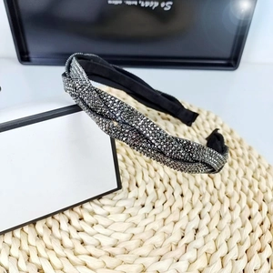 Close-up of sparkling silver rhinestone braided headband with elegant wide knot design