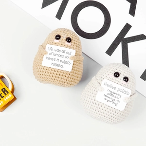 Detailtextur handgefertigter Häkel-Kartoffelpuppen mit kleinen Armen und Grußkarten