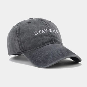 Detailed close-up of charcoal gray washed denim cap with Stay Wild white embroidery
