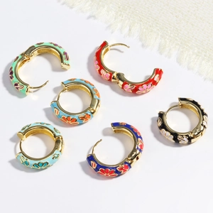 Golden hinged hoop earrings with colorful enamel floral patterns on a clean background