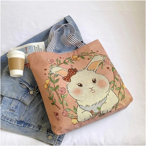 Pink canvas tote bag featuring an embroidered rabbit and floral wreath with striped handles