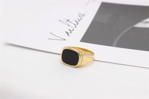 Vue détaillée d'une bague chevalière dorée avec une incrustation rectangulaire noire