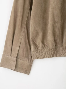 Détail des poignets côtelés et de l'ourlet élastique sur veste en daim marron