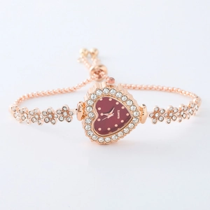 Detail of rose gold heart-shaped watch with red dial and adjustable crystal bracelet
