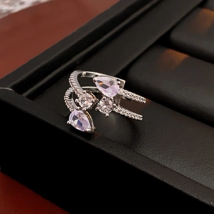 Detailed view of layered silver ring with purple teardrop zircon in black leather box