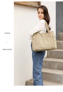 Outdoor shot showing the large capacity canvas tote bag worn by a model on a shoulder