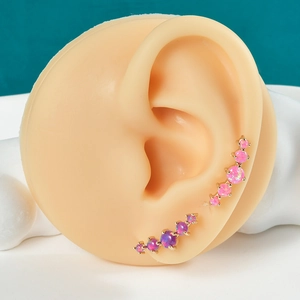 Detail of curved stainless steel ear crawlers with pink and purple synthetic opal stones