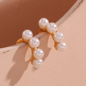 Détail d'un ear cuff plaqué or 18 carats orné de quatre perles blanches sur céramique