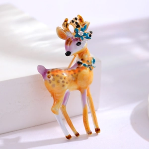 Broche cerf sika en émail avec détails floraux et strass sur fond blanc épuré