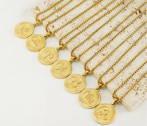 Détail de pendentifs signes du zodiaque plaqués or 18 carats sur pierre naturelle