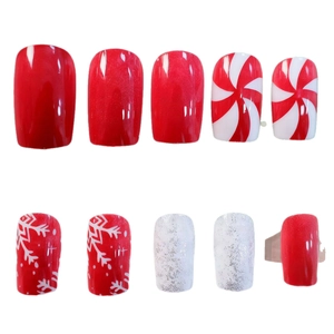 Christmas press-on nails featuring red glitter, white snowflakes, and candy cane swirls