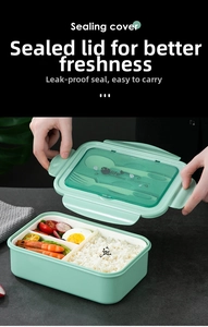 Close-up of a three-compartment mint green bento box with built-in cutlery storage