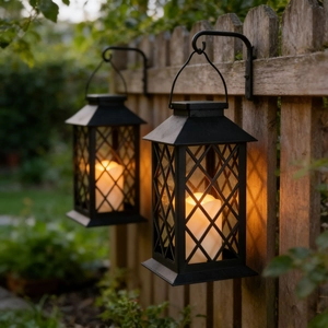 Set of two vintage black metal outdoor lanterns with warm LED candles for patio decor
