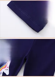 Detailed view of unicorn embroidery and double-needle hem on navy blue girls' leggings