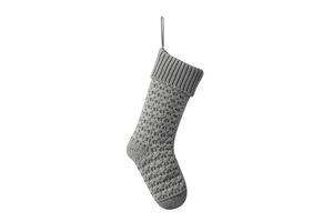 Close-up of grey knitted Christmas stocking with embossed patterns and ribbed cuff