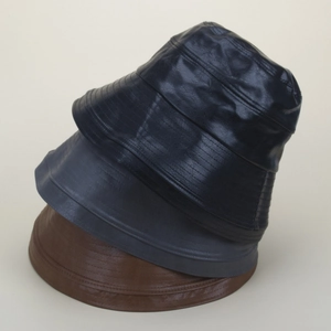 Trois bobs en similicuir noir, bleu et marron avec détails de bord surpiqués