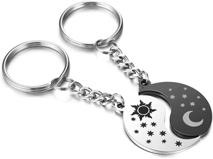 Detail of sun and moon puzzle pendants in silver and black stainless steel for couples
