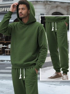 Close-up of knit texture on men's dark green hooded tracksuit with drawstring details
