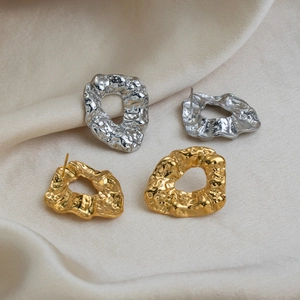 Detailed shot of molten metal texture hoop earrings in gold and silver finishes