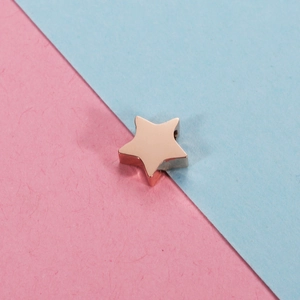 Polished rose gold stainless steel star pendant bead on pink and blue background