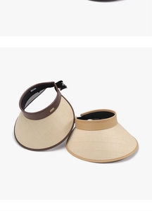 Detail of woven straw sun visors with PU leather trim and wide brim for UV protection
