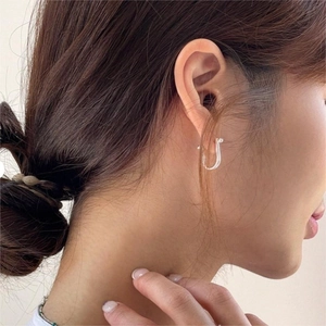 Minimalist 925 sterling silver U-shaped horseshoe stud earrings worn by a model
