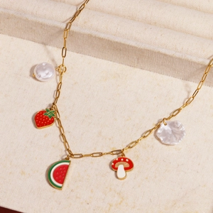 Detail of gold chain necklace featuring enamel fruit charms and irregular pearl