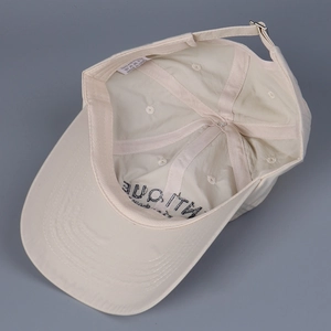 Detail of beige nylon baseball cap interior showing sweatband and adjustable metal buckle