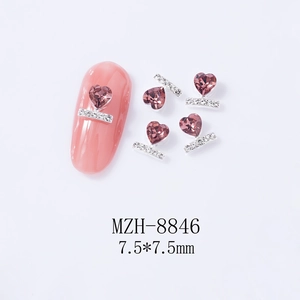 Macro detail of 7.5mm heart-shaped nail charm with pink rhinestone and silver base