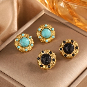 Close-up of vintage 18K gold plated earrings with turquoise and black marble stone inlay