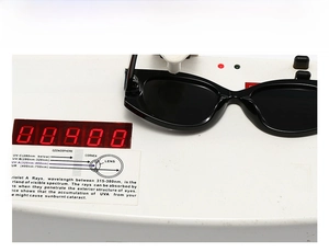 Detail van de UV400-beschermingstest op zwarte ovale zonnebrillen met marmerpatroon