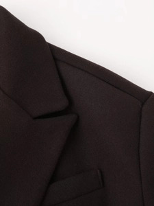 Close-up of black wool blend suit jacket featuring classic notched lapels and shoulder seams